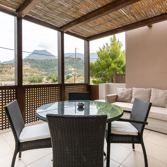 big terrace with couch and table with chairs in a two bedrooms superior apartment in plakias, rethymno, crete