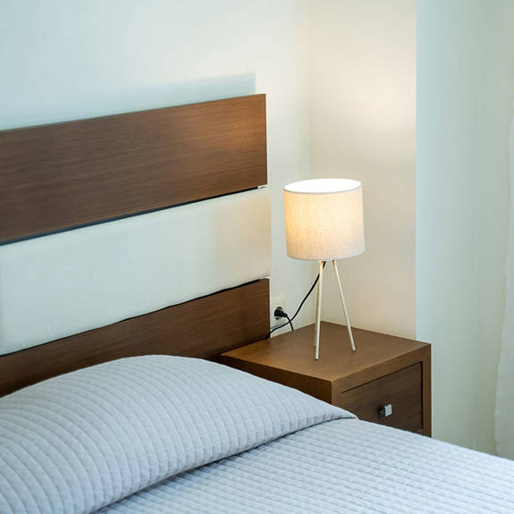 double bed with bedside table in a two bedrooms superior apartment in plakias, rethymno, crete