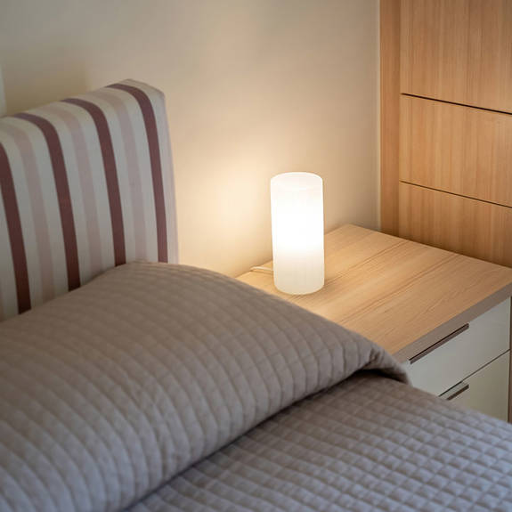 bed with bedside table and lamp in a two bedrooms apartment in plakias, rethymno, crete