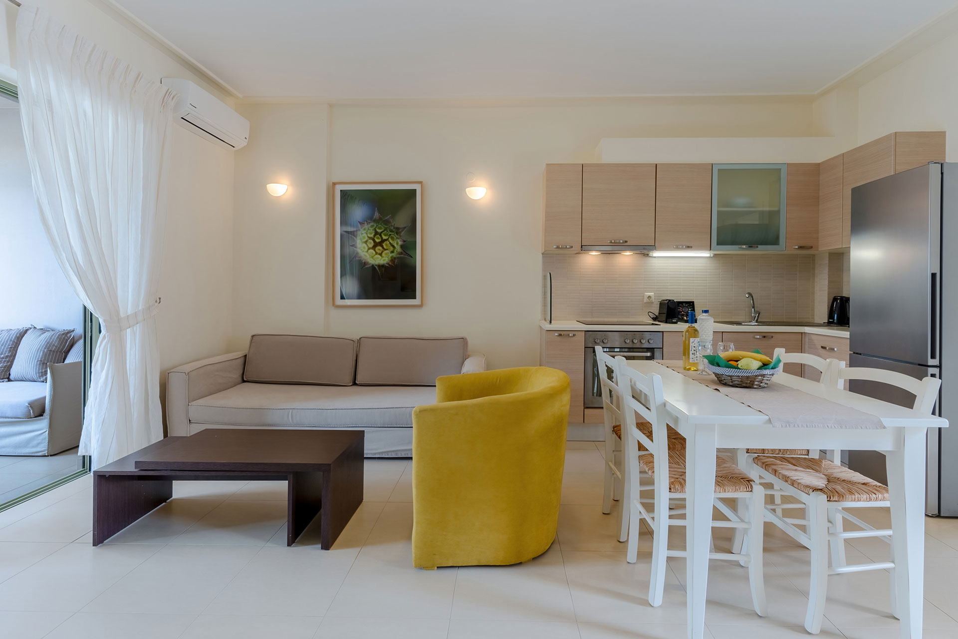 living room with couch and armchairs, and kitchen area in a two bedrooms apartment in plakias, rethymno, crete