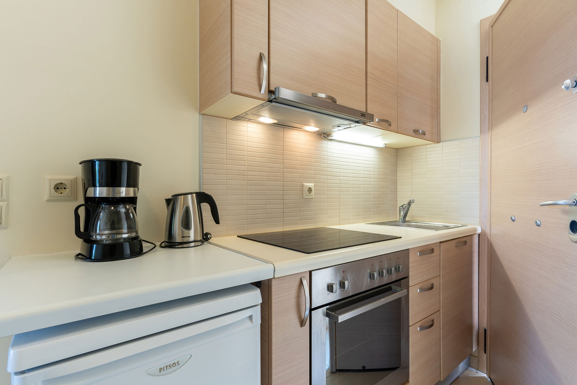 kitchen equipped with coffee maker, kettle, oven, fridge in a studio in plakias, rethymno, crete