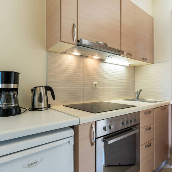 kitchen equipped with coffee maker, kettle, oven, fridge in a studio in plakias, rethymno, crete