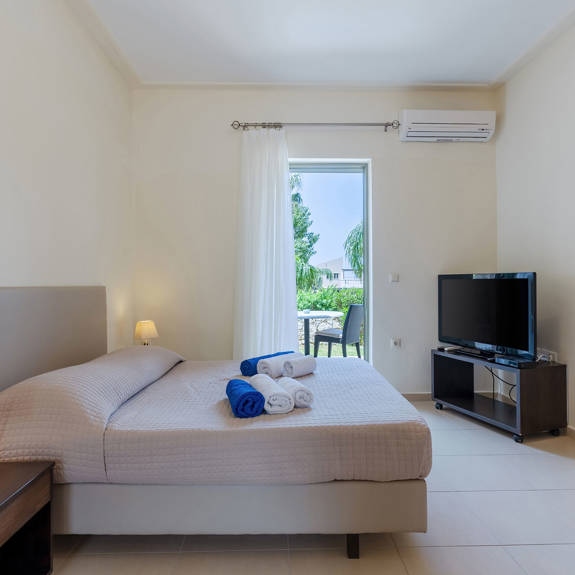 bedroom with air-condition, tv and terrace in a studio in plakias, rethymno, crete