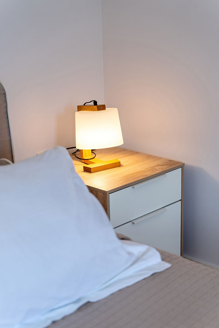 bed with bedside table in a three bedrooms villa with pool and sea view in plakias, rethymno, crete