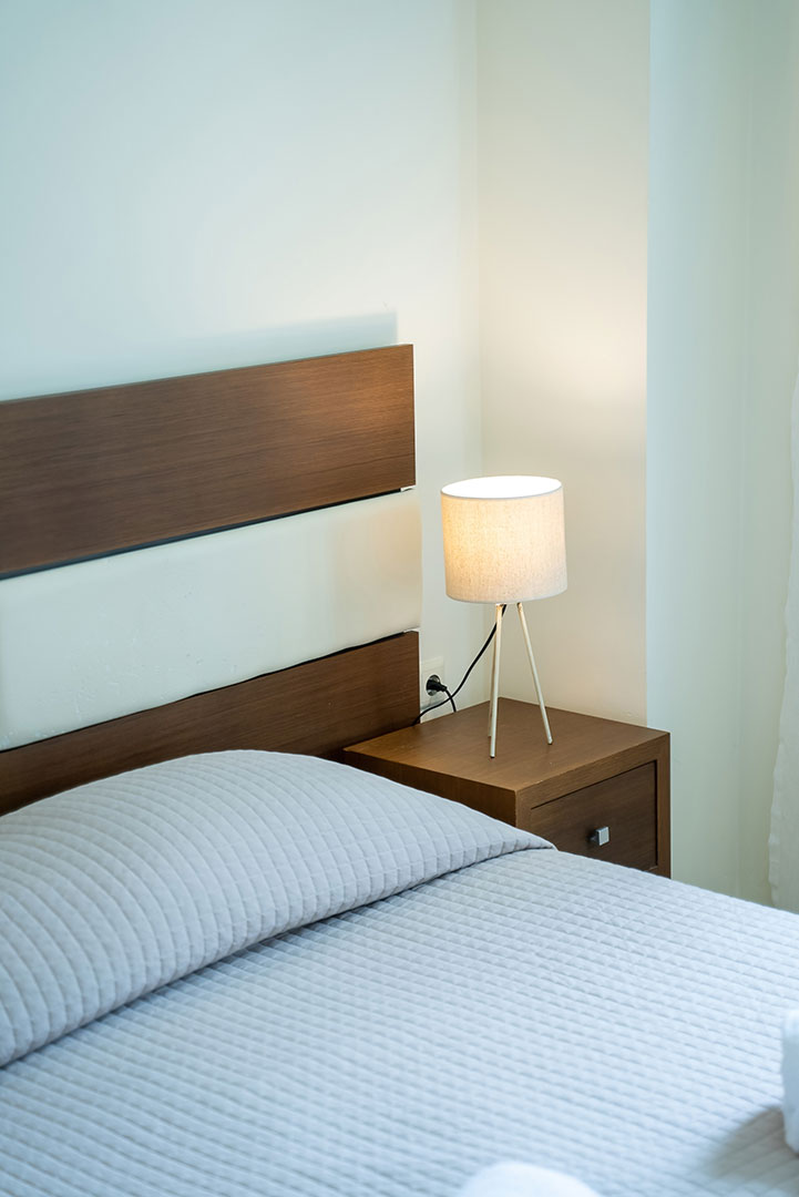 double bed with bedside table in a two bedrooms superior apartment in plakias, rethymno, crete