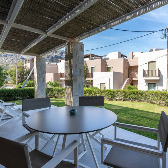 terrace in the garden with table and chairs in an one bedroom apartment in plakias, rethymno, crete