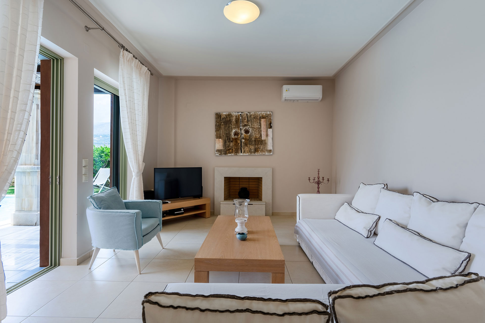 living room with fireplace and large couch in a three bedrooms villa with sea view in plakias, rethymno, crete