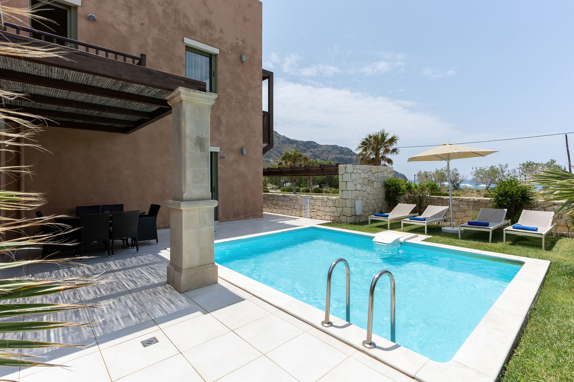 swimming pool with lawn in a three bedrooms villa with pool and sea view in plakias, rethymno, crete