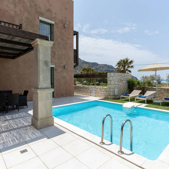 swimming pool with lawn in a three bedrooms villa with pool and sea view in plakias, rethymno, crete