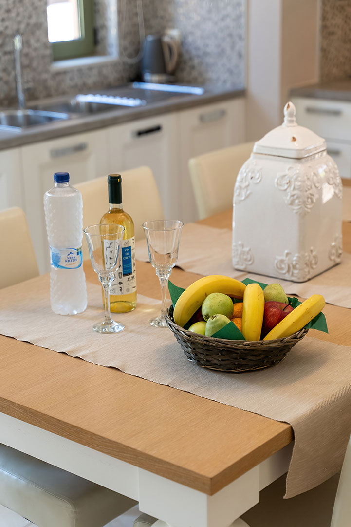 cozy kitchen with counter with fruits, wine and bottle of water in a three bedrooms villa with pool and sea view in plakias, rethymno, crete