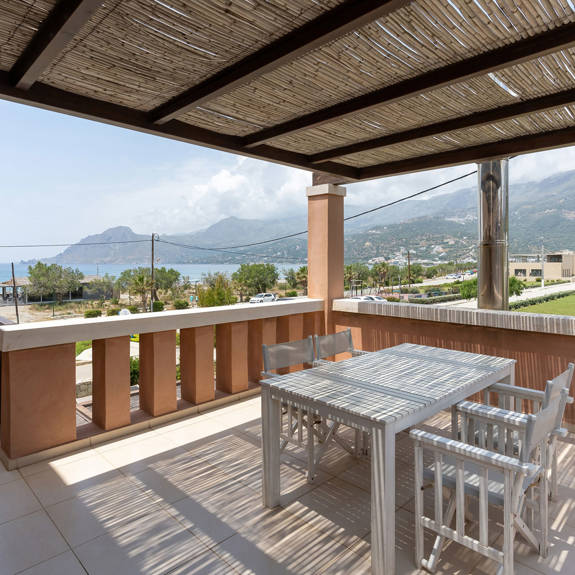 big terrace with white furniture and cane canopy in a three bedrooms villa with sea view in plakias, rethymno, crete