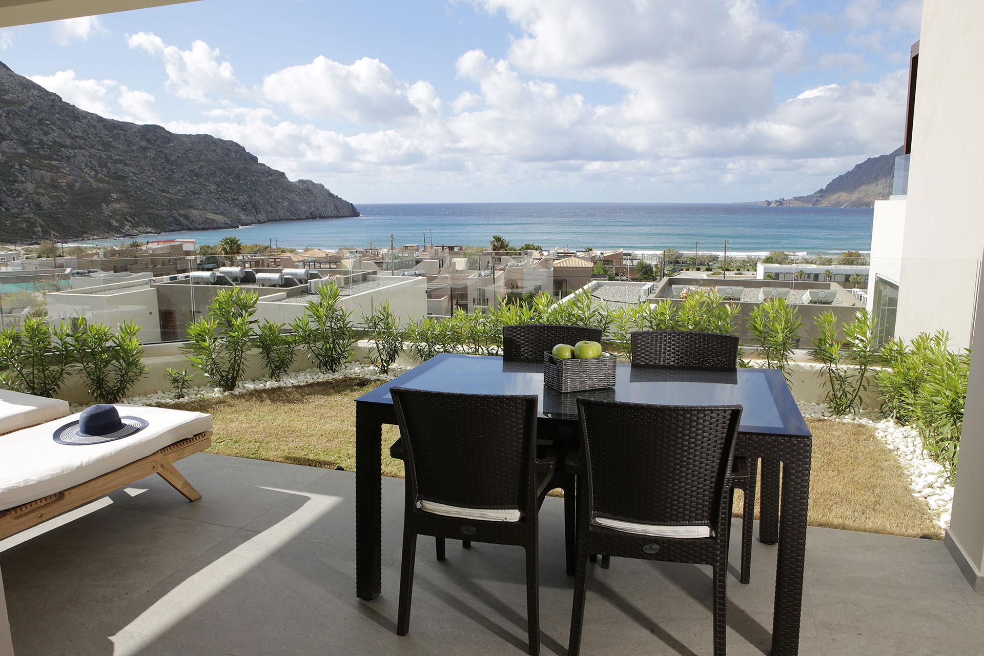 large terrace with sea view, sunbeds and table with chairs in a two bedrooms superior apartment in plakias, rethymno, crete