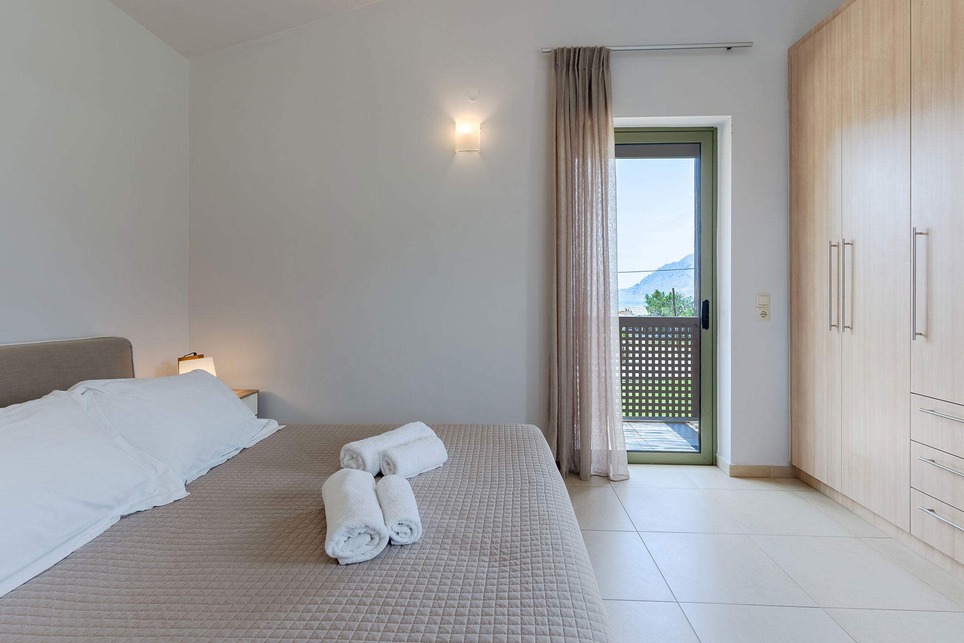 double bed bedroom with towels and closet in a three bedrooms villa with sea view in plakias, rethymno, crete