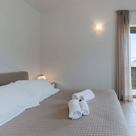 double bed bedroom with towels and closet in a three bedrooms villa with sea view in plakias, rethymno, crete
