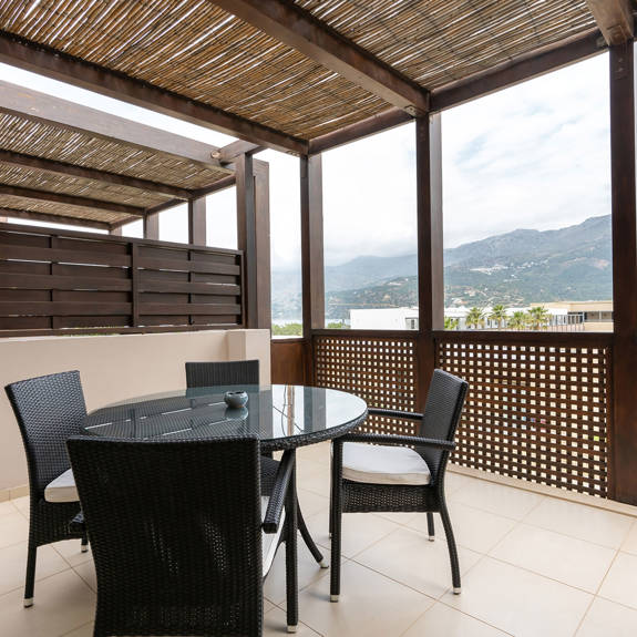 big terrace with table and chairs in a two bedrooms superior apartment in plakias, rethymno, crete