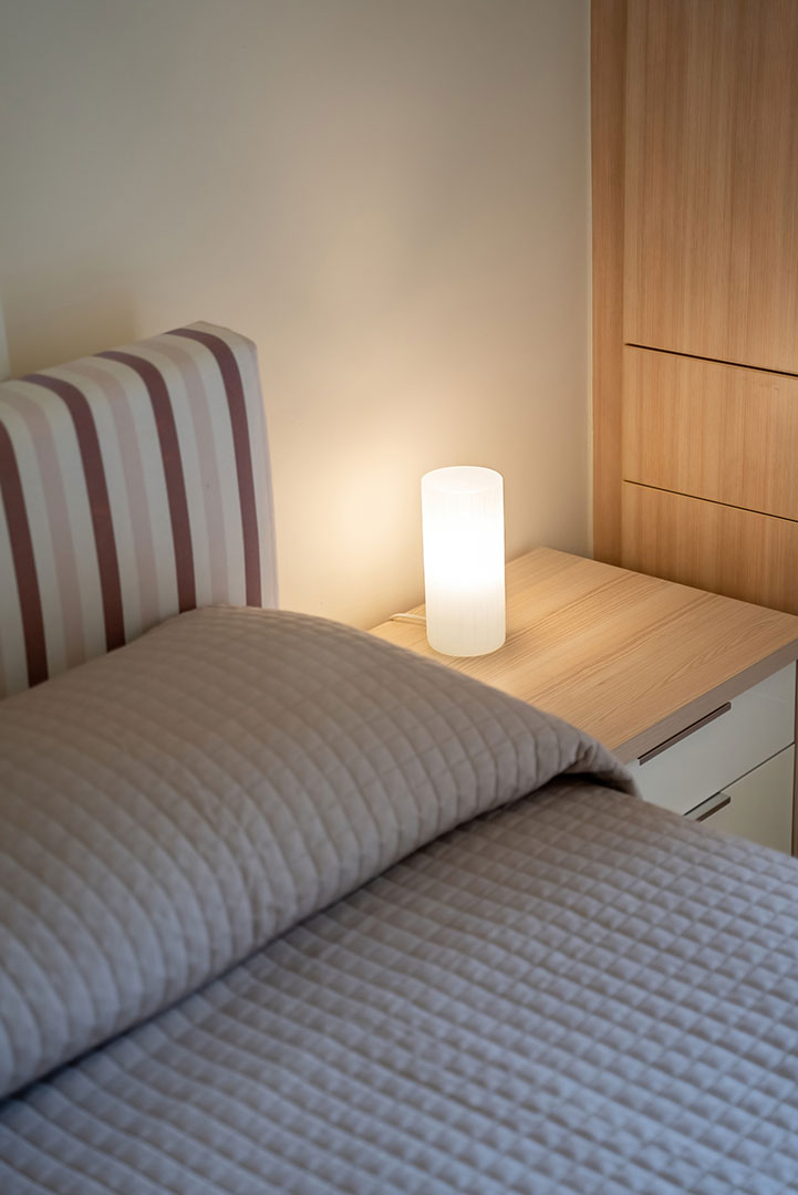 bed with bedside table and lamp in a two bedrooms apartment in plakias, rethymno, crete