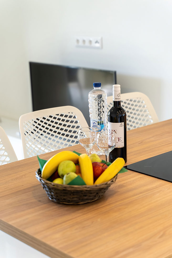 kitchen counter with fruits, wine and bottle of water in a two bedrooms maisonette in plakias, rethymno, crete